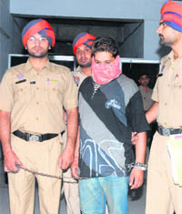 Pawan Kumar, who was arrested on a charge of smuggling heroin, in police custody in Jalandhar on Saturday.