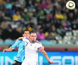 Frances Frank Ribery (R) fights for the ball with Maximiliano Pereira of Uruguay on Friday.