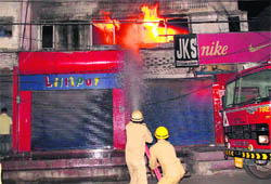 Firemen try to douse the fire that broke out at a godown near Chief Minister Omar Abdullahs official residence at Residency Road in Jammu on Saturday.