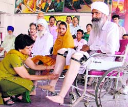 A physically challenged person gets prosthetics at a free artificial limb distribution camp in Ludhiana on Sunday