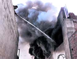 A fireman douses a blaze at a hosiery unit in Ludhiana on Sunday