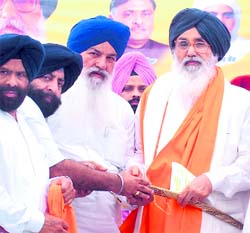 Punjab Revenue Minister Ajit Singh Kohar along with local leaders presents a sword to Chief Minister Parkash Singh Badal at a public meeting in Jalandhar on Sunday