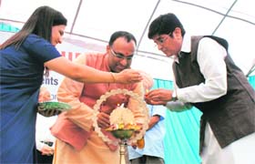 Dr Kiran Bedi lights a lamp at a function in Banur