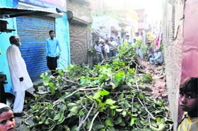Residents of Jwalapur Peeth Bazar at the site where a tree fell on a marriage tent in Haridwar