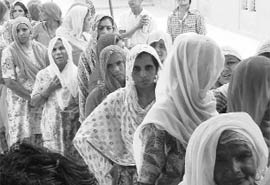 Women wait for their turn to vote in a village near Sirsa