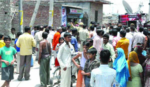 People gather outside the house at Swaroop Nagar where the young couple was found dead on Monday.