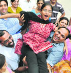Shilpa Garg of BCM Sr Sec School, who topped Punjab in the Class X PSEB results, is lifted into the air by her jubilant teachers in Ludhiana.