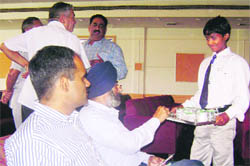 An underaged worker serves beverages at a function in Mandi Ahmedgarh. 