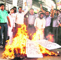 BJP and BJYM activists burn an effigy of Congress leader Arjun Singh in Ludhiana on Monday. 