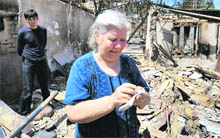 An ethnic Uzbek woman cries as she stands beside the wreckage of her house in Osh on Monday. 