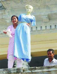 Congress councillor Preeti along with a mannequin stands on the roof of Town Hall