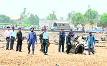Personnel of the IAF inspect the area where a MiG 21 crashed in Raikot on Tuesday. 
