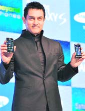 Bollywood star Aamir Khan poses with Samsung mobiles at their launch in New Delhi on Wednesday. Samsung launched two new models, Wave and Galaxy S, priced at Rs 19,100 and Rs 32,500, respectively.