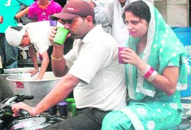 A couple has sweetened water at a chhabeel set up in connection with the martyrdom day of Guru Arjan Dev in Bathinda