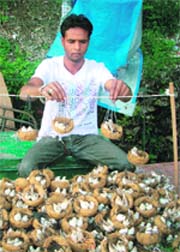 A vendor sells artificial sparrow nests in Mussoorie.