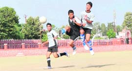 A player heads the ball during a match of the Dehradun Football League played at the Police Lines Ground in Dehradun on Thursday.