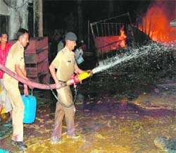 Fire fighters douse fire at Ranipur Jhal in Haridwar on Wednesday.