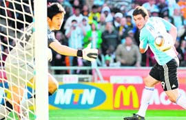 Argentina's striker Gonzalo Higuain scores as South Koreas goalkeeper Jung Sung-Ryong misses.