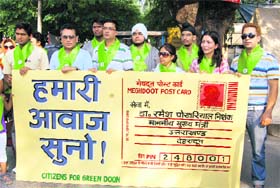 Members of the Citizens for Green Doon with a large postcard in Dehradun
