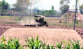 A farmer ploughs his field near the fencing on the Zero Line