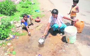 With water scarcity looming large in the region, a woman fetches water from a roadside trench at Channi Himmat in Jammu.