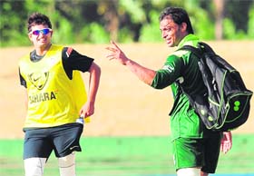 Pakistans Shoaib Akhtar (R) gestures as Indias Suresh Raina looks on during a training session in Dambulla