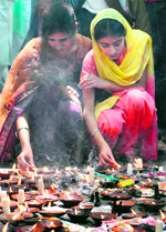 Kashmiri Pandit women light oil lamps at the Khirbhawani temple in Tullamulla in Ganderbal district