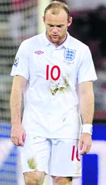 A dejected Wayne Rooney walks back after Englands match against Algeria on Friday.