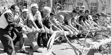 Ethnic Uzbeks and Kyrgyz jointly dismantle a street barricade on the border of Uzbek district in Osh, on Saturday, following recent ethnic violence in the city.