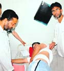 Relatives with a youth injured in CRPF firing at a hospital in Srinagar on Sunday. 