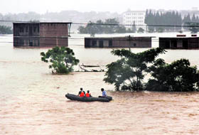 Rescuers use a lifeboat to search stranded people in flooded areas in Yingtan county, Jiangxi province on Sunday. Floods and landslides across southern China have killed at least 132 persons and left 86 missing in a week, Xinhua news agency said. 