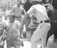 Cops canecharge a woman who was protesting against the demolition drive at Phase I in Mohali