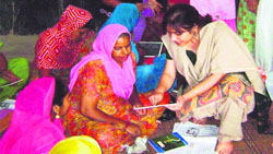 Ashima Sabharwal, chairperson of the Sirsa unit of the AFWWA, gives lessons of literacy to women in Meerpur village in Sirsa. 