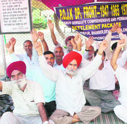 Refugee Front activists stage a protest outside the Divisional Commissioners office in Jammu on Monday.