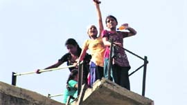 AIE teachers stage a protest atop an overhead water tank near Bathinda on Monday.