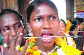 A devotee pierces her tongue in a procession of Goddess Sheetla Mata in Patiala on Monday.