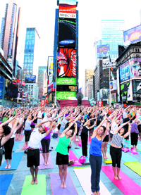 People gather to practice yoga on the morning of the summer solstice in New York's Times Square on Monday. The eighth annual "Solstice in Times Square" event brought out thousands of participants to celebrate the year's longest day
