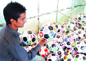 A youngster plays with footballs displayed in a hotel