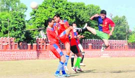 A player heads the ball during a match of the Dehradun Football League played at the Police Lines Ground in Dehradun on Tuesday.