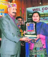 Himachal Irrigation and Public Health Minister Ravinder Ravi presents the Himachal Kesari Award to Urmil Sharma for her feats in the field of sports.