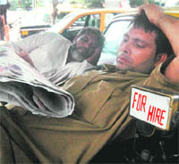 A cabbie reads newspapers during a strike in Mumbai on Tuesday. 