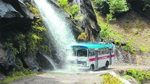 A bus passes through a waterfall on the Kishtwar-Paddar road, 310 km from Jammu.