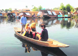 Foreigners enjoy a ride on a boat in Dal Lake in Srinagar.