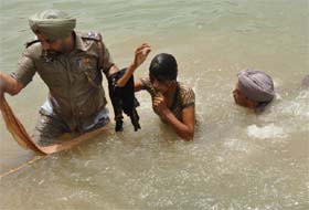 Nehianwala SHO Gurpreet Singh pulling out an AIE protester, who had jumped into a water reservoir, at Bhokhra village in Bathinda
