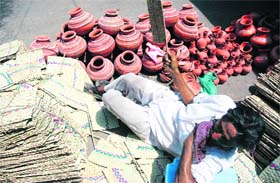 A vendor awaits buyers of traditional hand fans at Arya Samaj Chowk in Patiala on the occasion of Nirjala Ekadashi