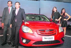 Managing Director of Hyundai Motors India WB Park (2nd from L), director marketing Arvind Saxena (L), and models pose with a Verna Transform at its launch in New Delhi