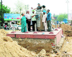 Literary and social organisation members cleaning the statue of Prof Mohan Singh with milk.
