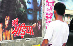 A passerby looks at an obscene poster in Ludhiana.