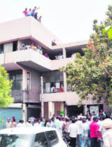 Workers of the Bharatiya Valmiki Seva Dal with kerosene bottles atop the MC-C Zone building protest in Ludhiana on Wednesday.