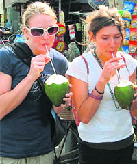 Foreign visitors drink coconut water to get respite from the scorching heat in Faridabad.